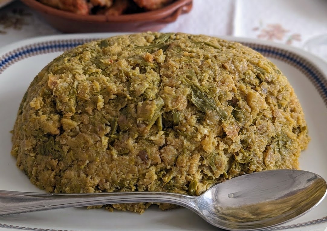 Migas alentejanas de grelos, servidas em forma de domo num prato branco