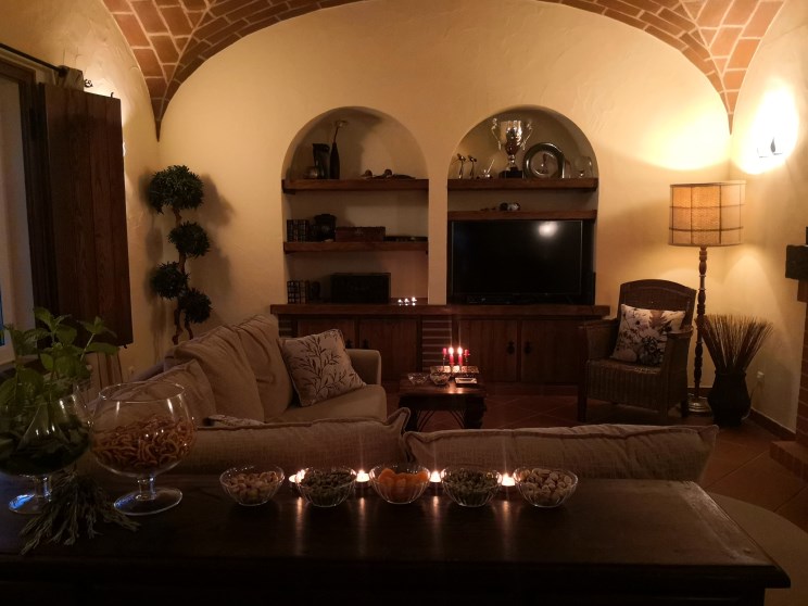 Sala de estar com tectos abobadados em tijolo e lareira, ao serão