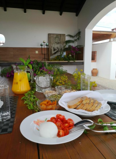 Pequeno-almoço servido no alpendre, com sumos frescos, pão e fruta